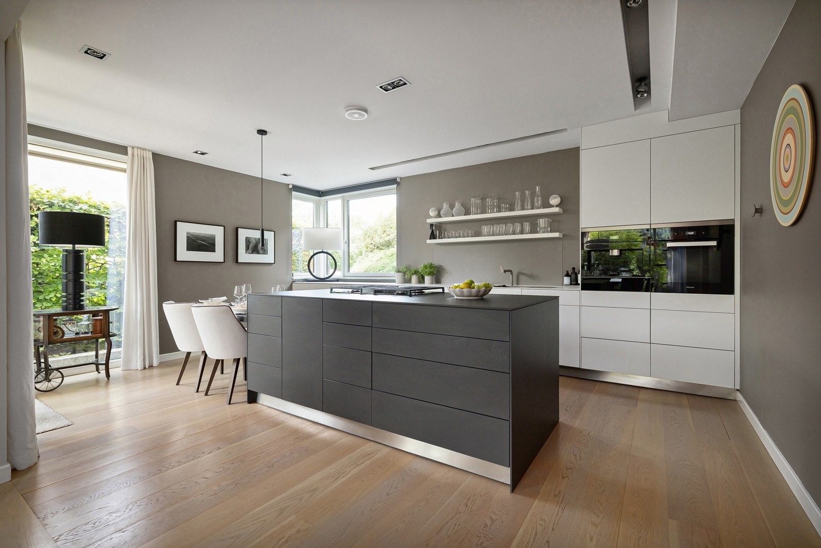 Stilrent Bulthaup-kjøkken, oppgradert med nye høyskap i hjørnet i 2021. Kjøkkenet har hvite, glatte fronter på skuffer og skap med praktisk push-to-open-funksjon. Stor kjøkkenøy i samme eksklusive kvalitet, med sorte fronter på skuffer og skap. Galleribilde