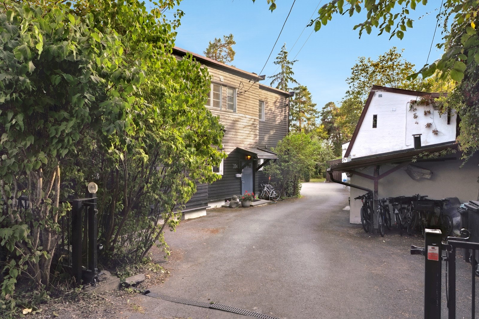 Adkomst i stikkvei ned fra Fagerhøyveien - port i innkjøringen. Felles sykkelparkering. Hovedinngang til venstre. Det hvite bygget er snr. 5 i sameiet. Galleribilde