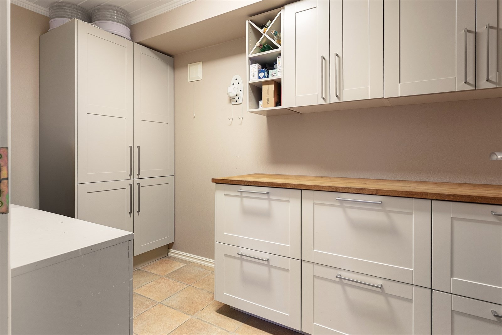 En innvendig bod er innredet med skap og en heltre benkeplate, ideell for hobbyaktiviteter. Galleribilde