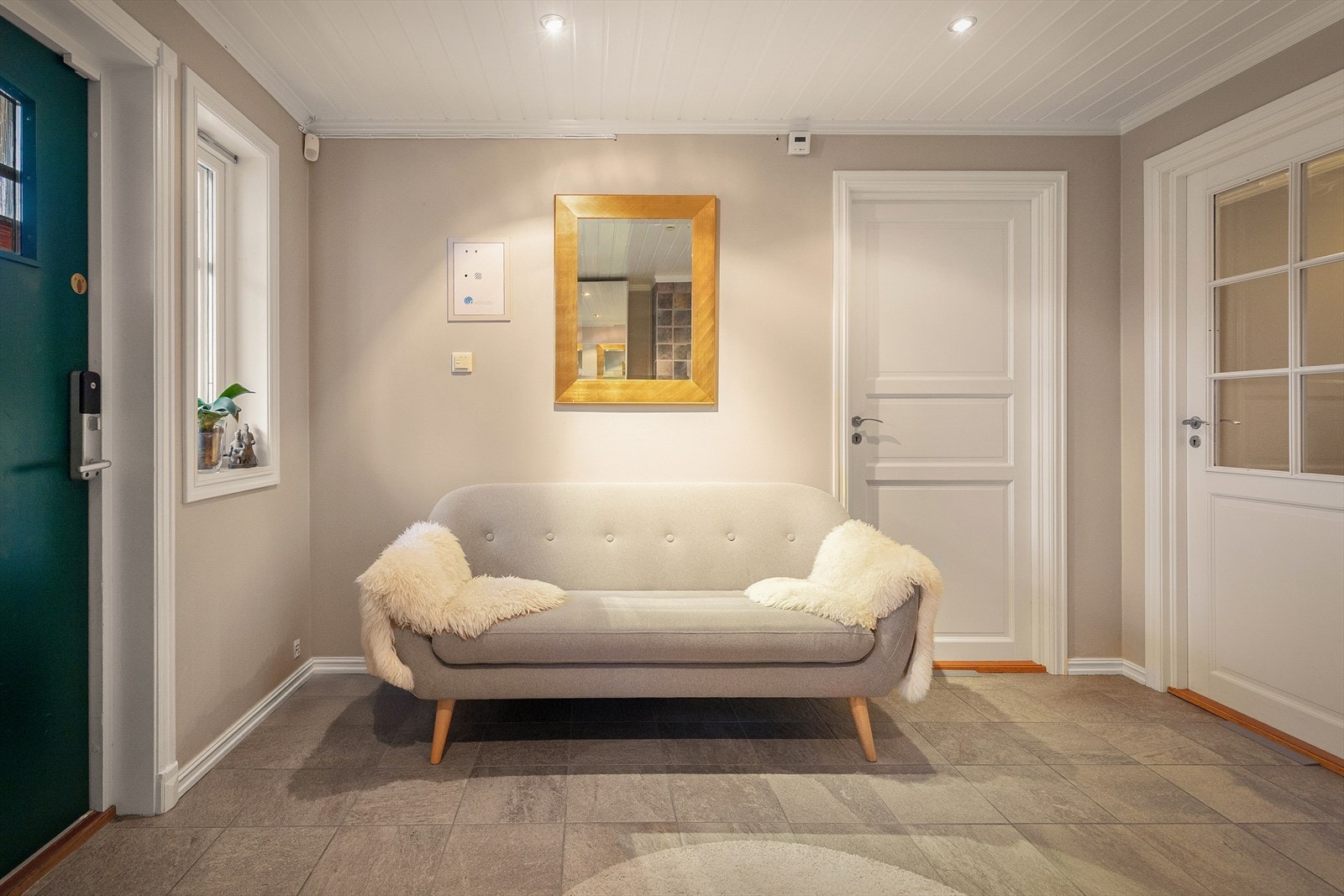 Fra et overbygget inngangsparti kommer du inn i en romslig hall med flislagt gulv og gulvvarme. Galleribilde