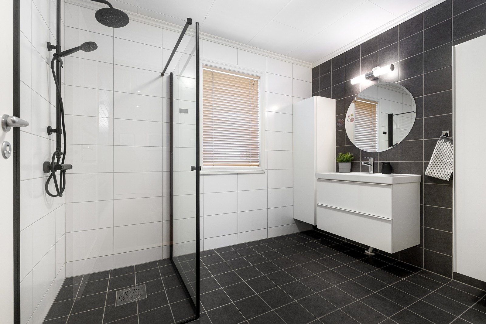 Badet i 1. etasje har flislagt gulv med gulvvarme og flislagte vegger. Stilrent dusjhjørne med innfellbare glassvegger. Galleribilde