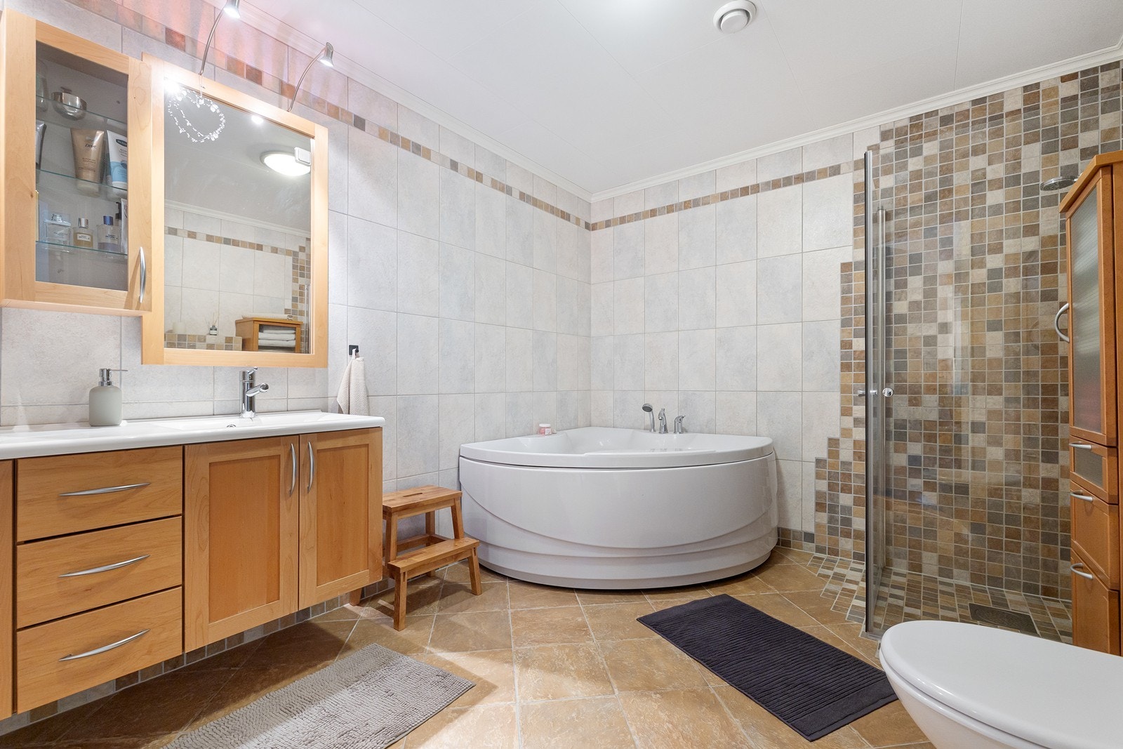 Badet i 2. etasje har flislagt gulv med elektriske varmekabler stort badekar, toalett og dusj. Galleribilde