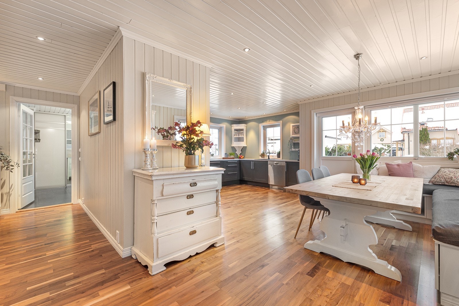 Åpen løsning mellom spiseplass og kjøkken med gjennomgående parkett. Galleribilde