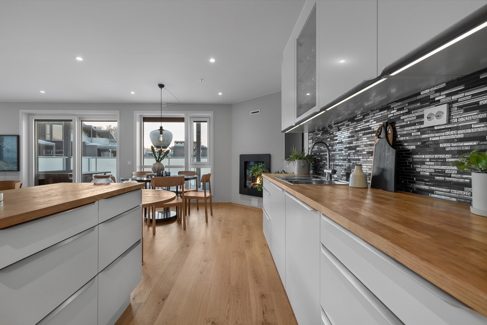 Kjøkkenet er i moderne utførelse med hvite fronter og skjulte gripelister Galleribilde