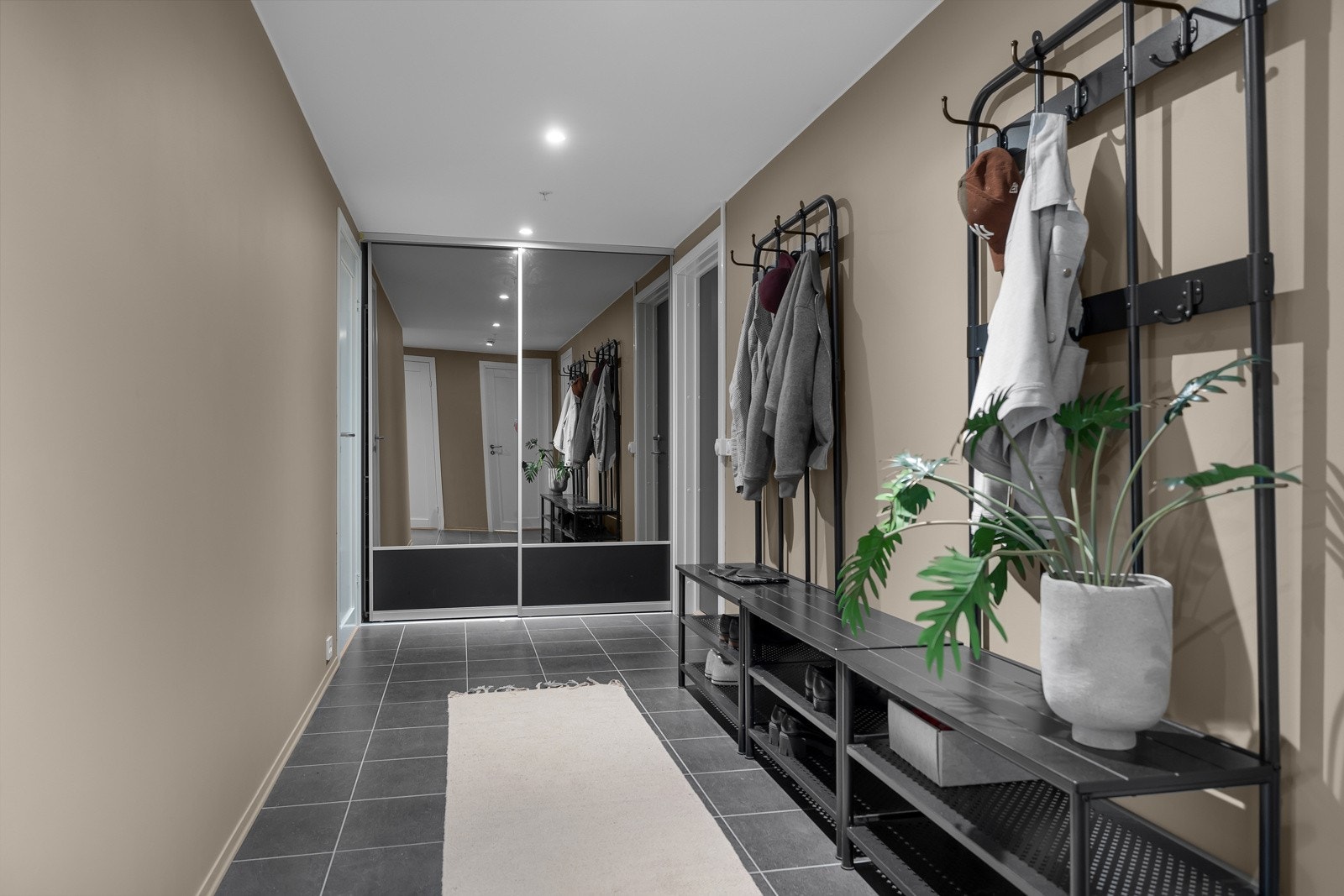 Inngangspariet leder deg først til en egen fløy med stort soverom og eget bad for så å lede deg videre inn til stue, kjøkken og "resten " av boligen Galleribilde