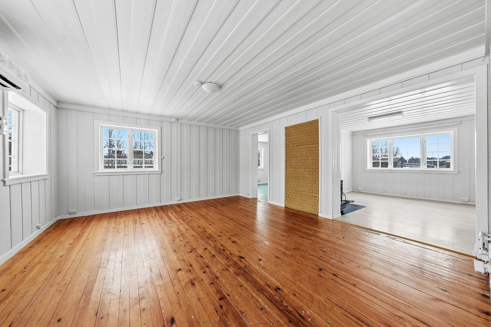 Lys og romslig stue med tregulv og store vinduer som gir godt med naturlig lys. Galleribilde