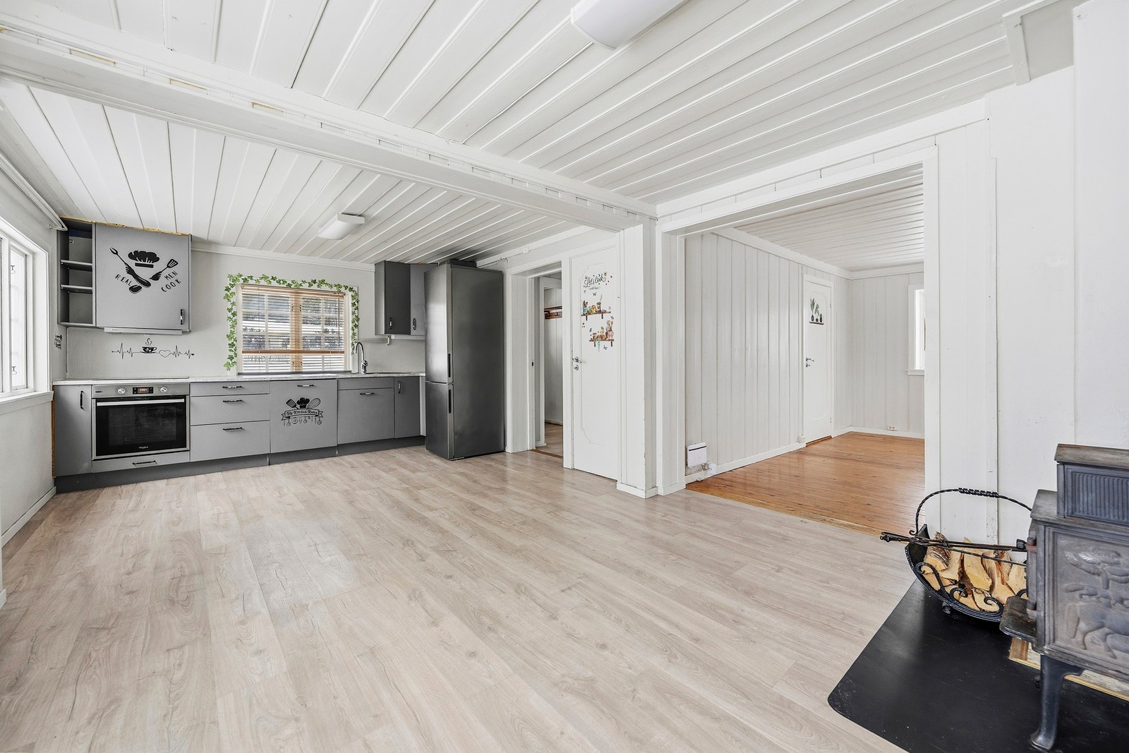 Kjøkken med god plass til spisebord og en vedovn. Galleribilde