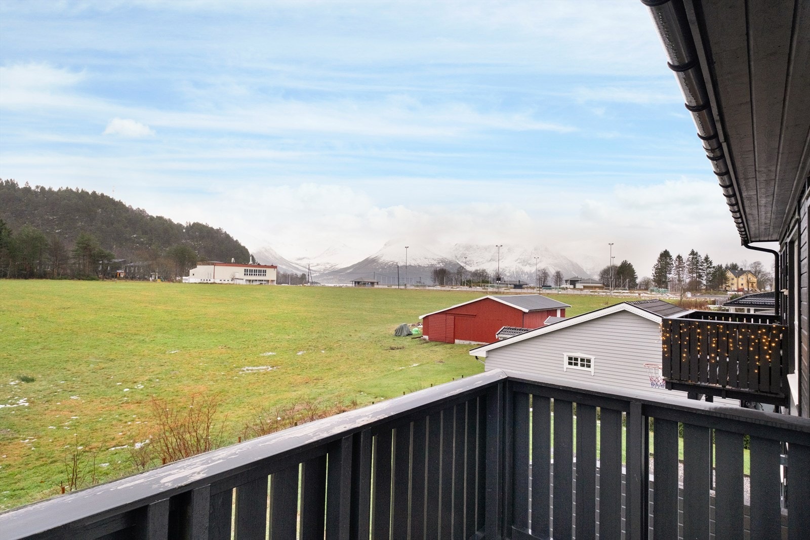Fra verandaen er det utsikt mot åpne landskap og fjell i det fjerne. Galleribilde