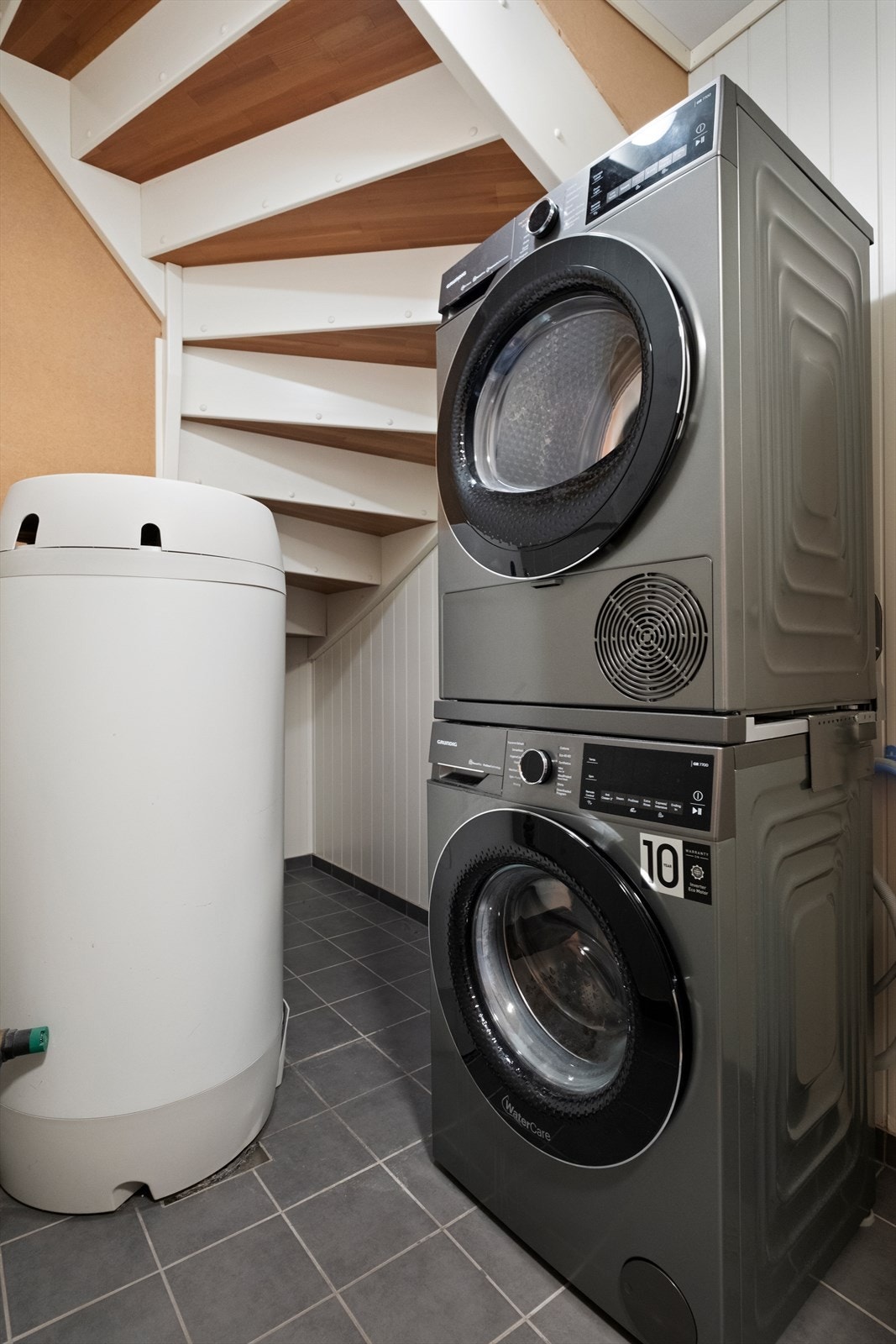 Vaskerommet har flislagt gulv og er utstyrt med oppegg for vaskemaskin og tørketrommel. Varmtvannstanken er også plassert her. Galleribilde