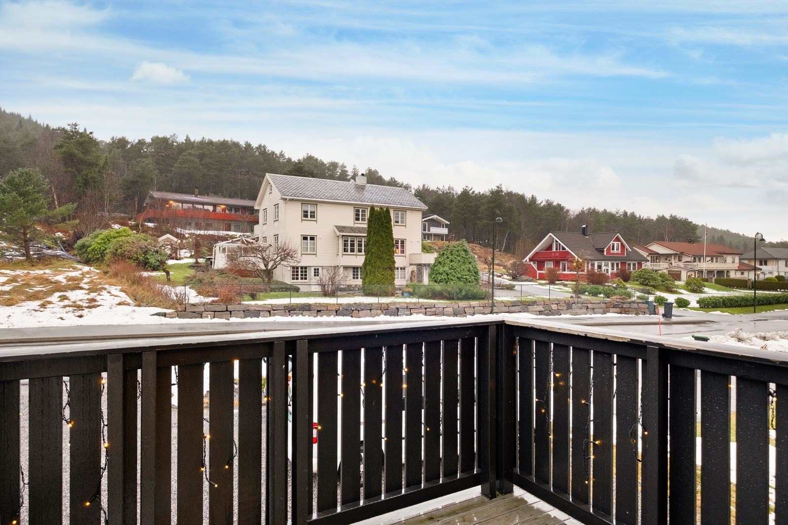 Verandaen i trevirke gir utsikt over nabolaget og omkringliggende grøntområder. Galleribilde