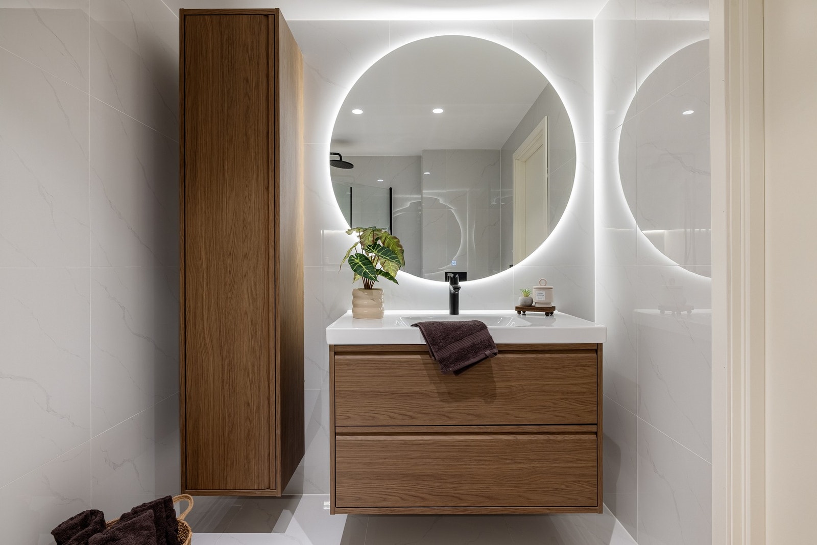 Badet er innredet med vegghengt toalett, dusj med glassvegger og baderomsinnredning. Galleribilde