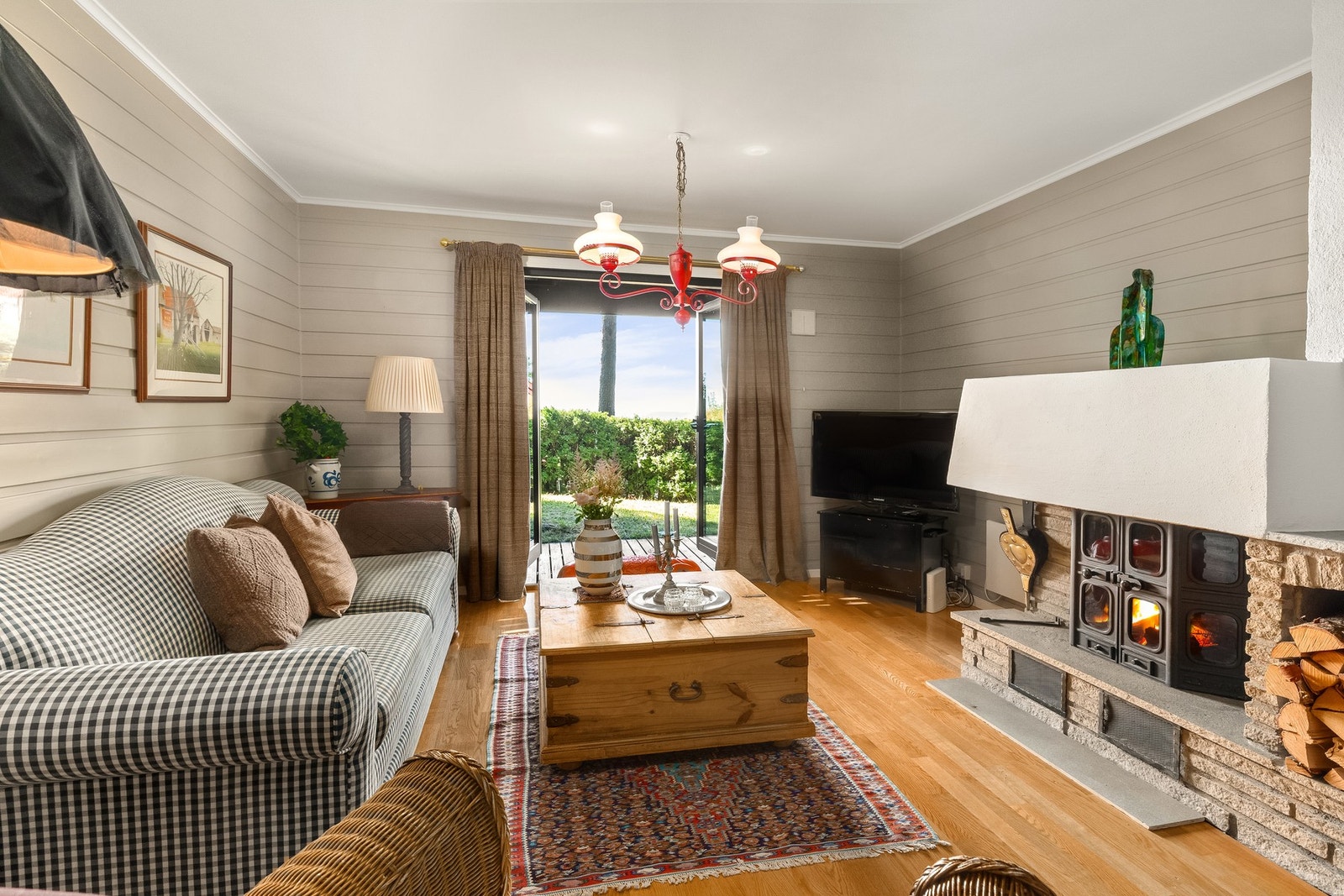 Romslig kjellerstue med peis og doble terrassedører (ny 2025) ut til plen Galleribilde