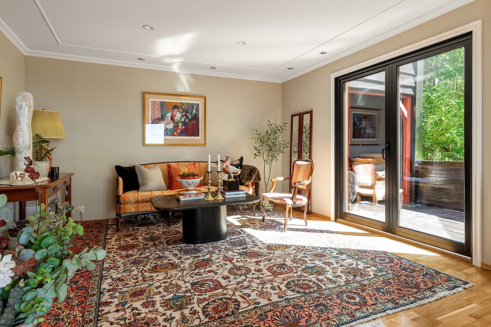 Hyggelig sofaområde med lys fra store vinduer og utgang til terrassen Galleribilde