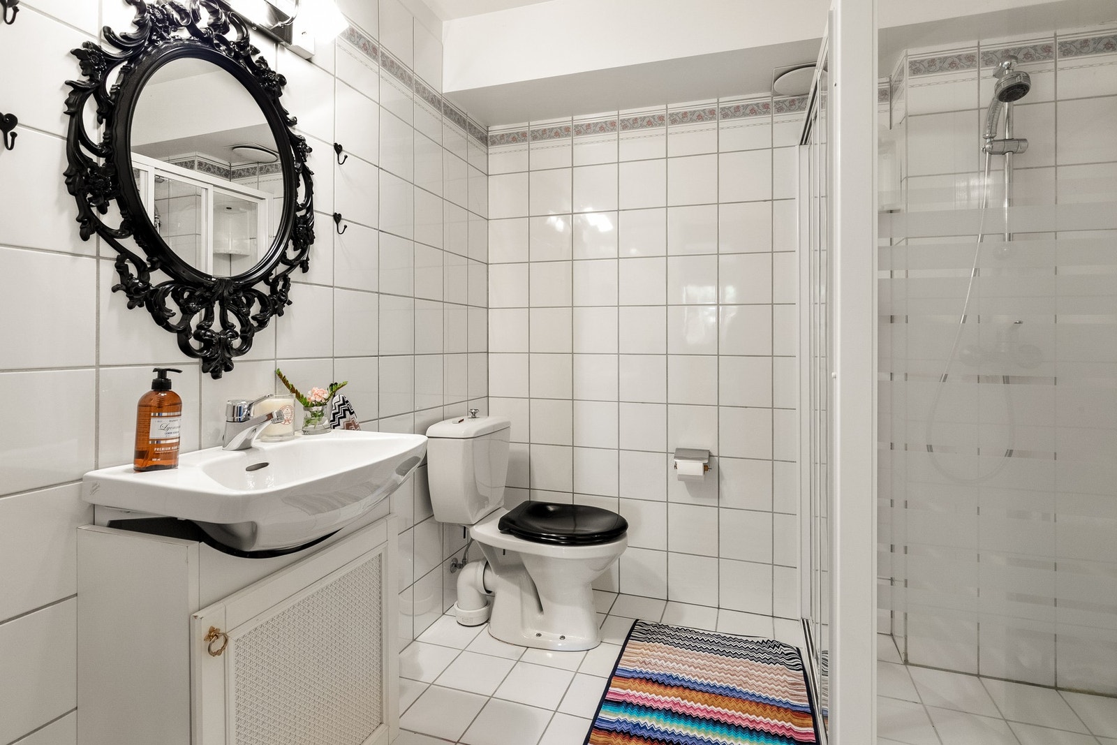 Flislagt bad i underetasjen - dusjkabinett, servant og gulvstående toalett Galleribilde