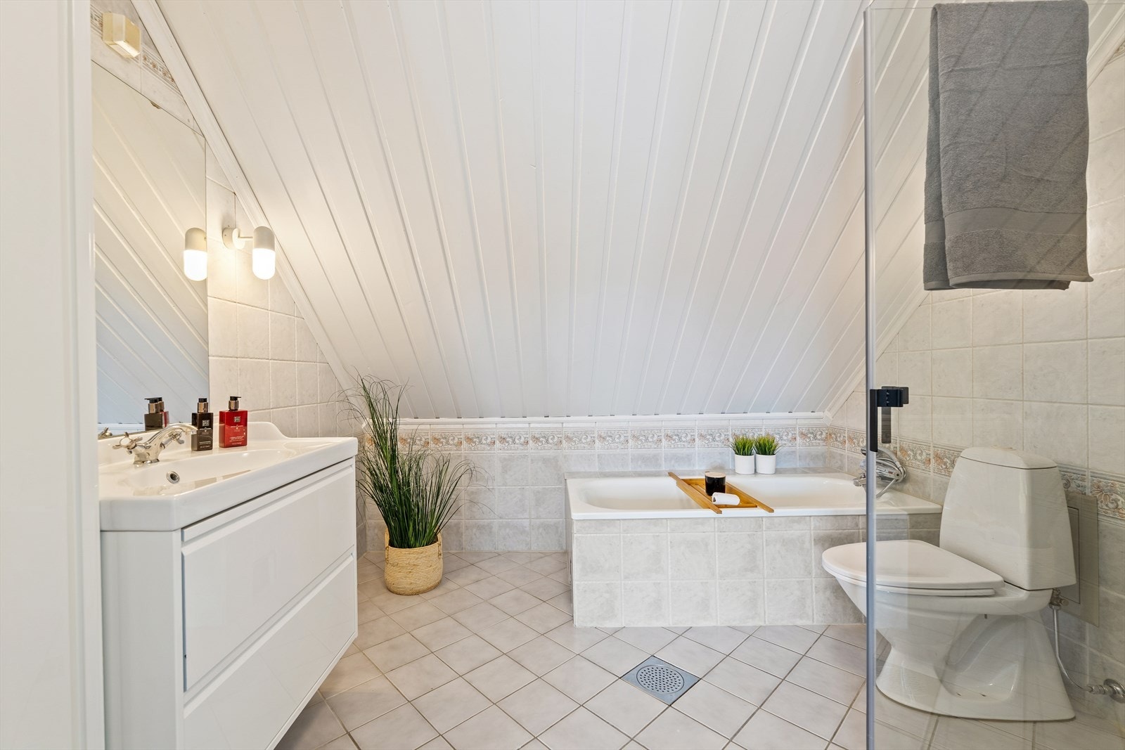 Badet er godt utstyrt med både dusjhjørne med glassdører, veggmontert dusjarmatur samt badekar med dusj- og badekararmatur. Videre har rommet gulvstående toalett. Galleribilde