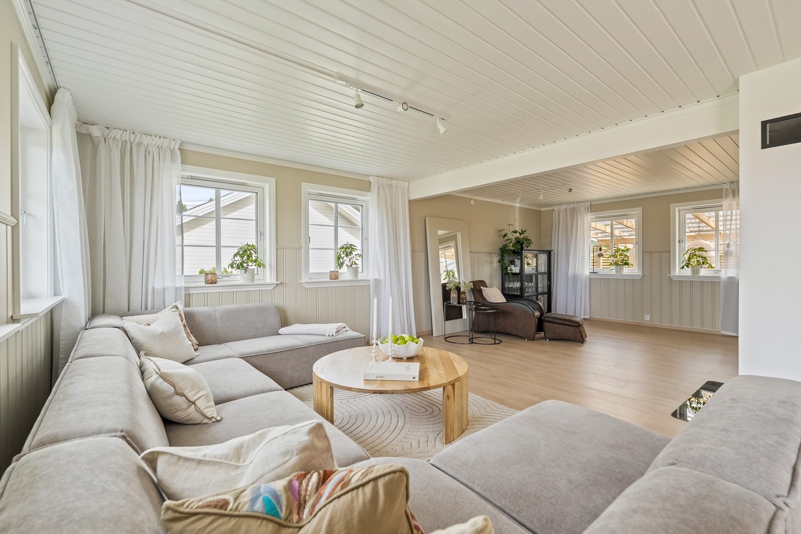 Stuen ligger i delvis åpen løsning mot kjøkkenet, noe som skaper en sosial og praktisk planløsning med god plass til både sofagruppe og spiseplass. Galleribilde