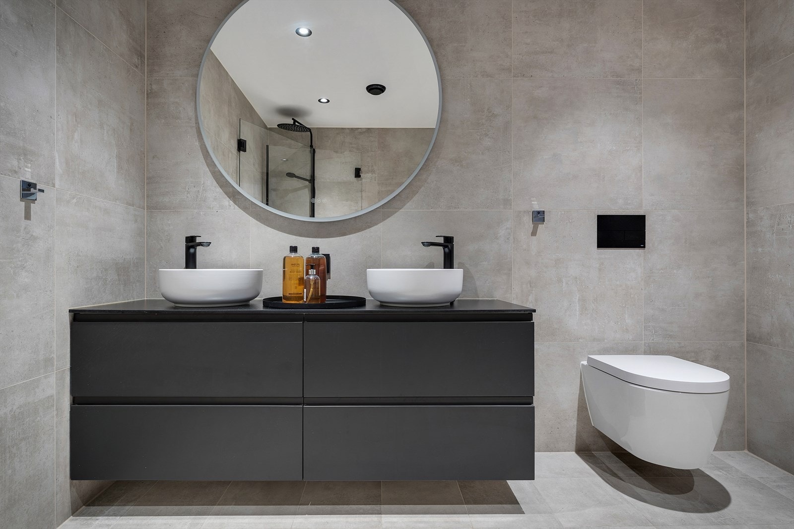 Badet har foldedører i dusj, veggtoalett og baderomsinnredning med heldekkende servant, samt belyst speil Galleribilde