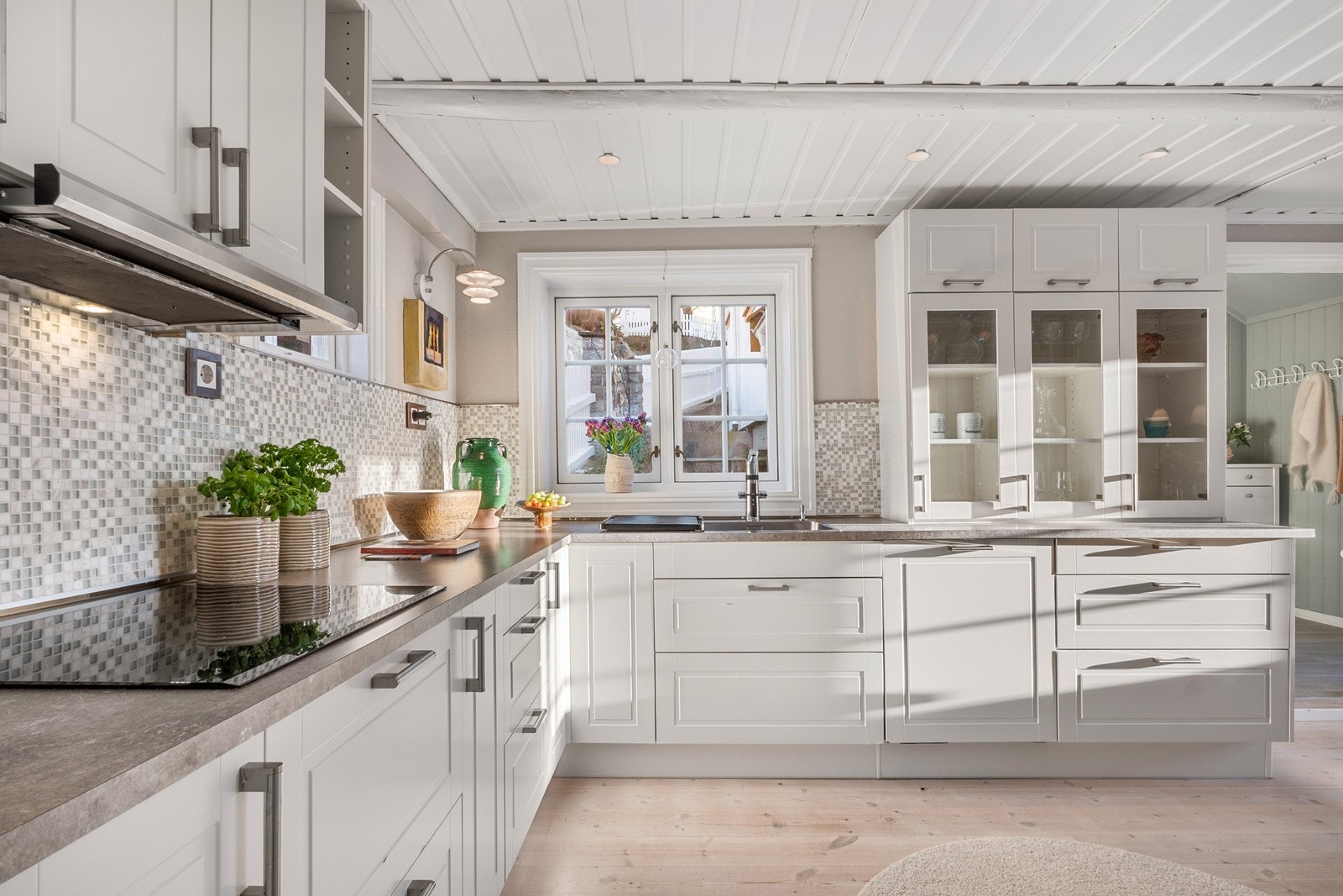 Det er godt med arbeidsflate på benk, mosaikkflis på vegg og integrerte hvitevarer. Galleribilde