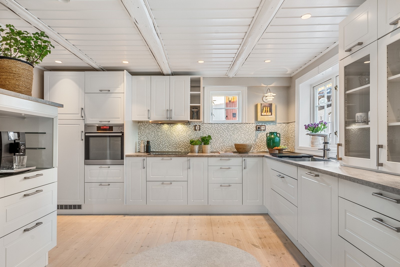 Over- og underskap med profilerte fronter, vitrineskap og hyller gir god oppbevaringsplass. Galleribilde