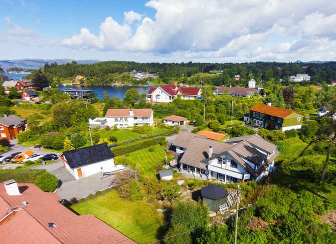 Midt i rolige og fine omgivelser - oversiktsbilde av området mot huset og mot sjøen. Galleribilde