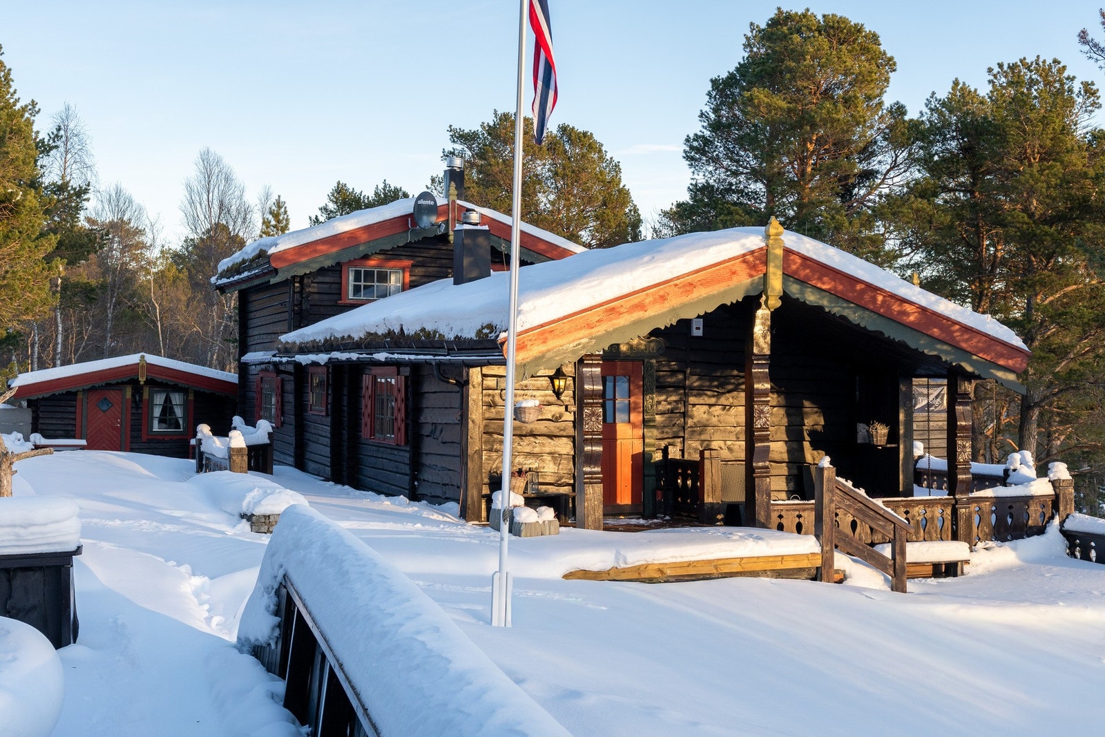 Håndlaftet tømmerhytte med gjennomgående standard. Flere uteplasser på begge sidene av hytta. Galleribilde