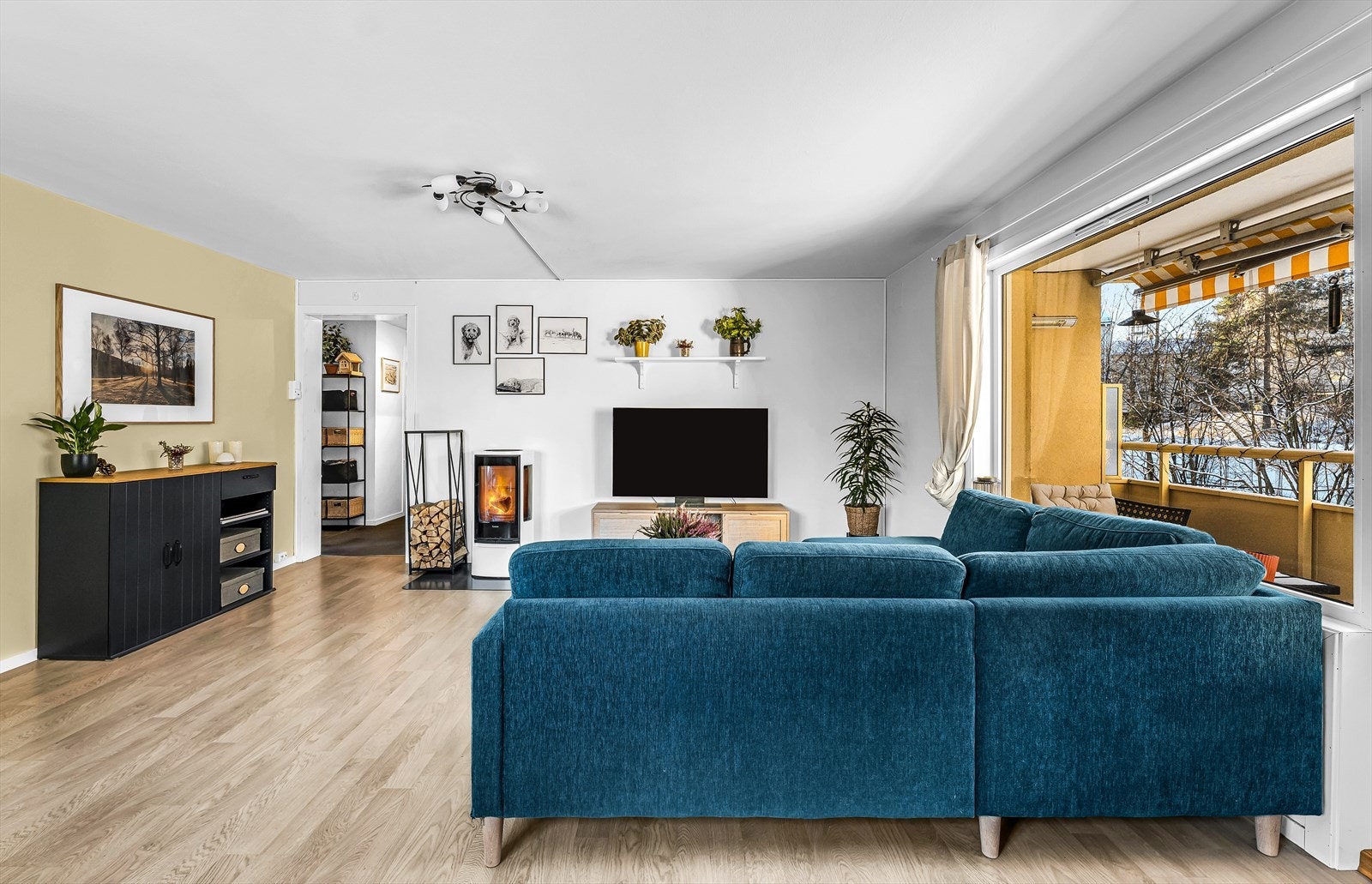 Stue og kjøkken oppleves som et sosialt og hyggelig oppholdsrom med ny peis fra 2020. Galleribilde