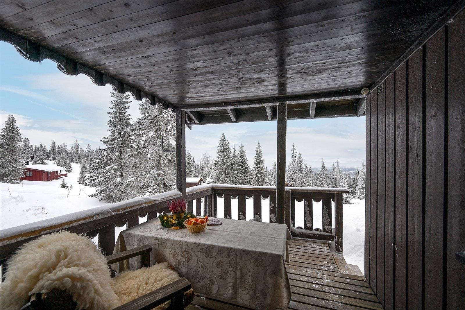 Utenfor inngangen er det en overbygd veranda for avslapning i hytteveggen. Galleribilde