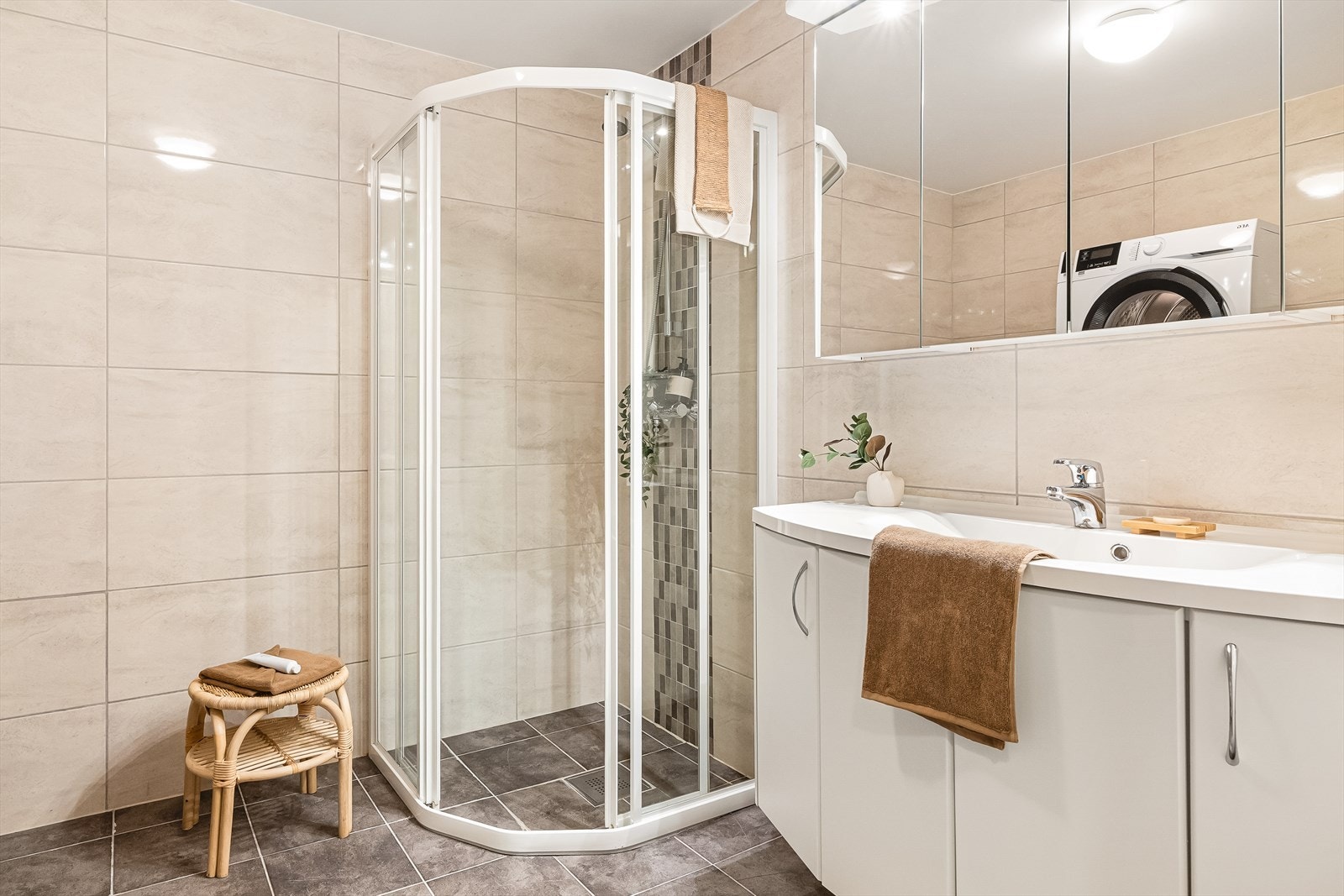 Bad er romslig, og innredet med nedfelt servant, vegghengt toalett, dusjhørne og opplegg for vaskemaskin. Galleribilde