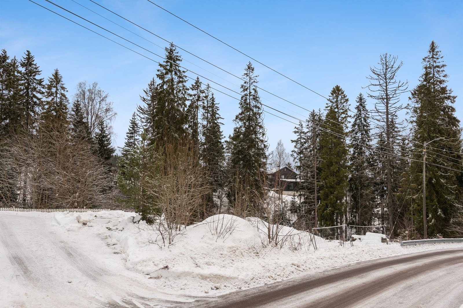 Tomten ligger på en liten høyde og deler av tomten er i sterkt skrånende terreng ned mot bekken. Galleribilde