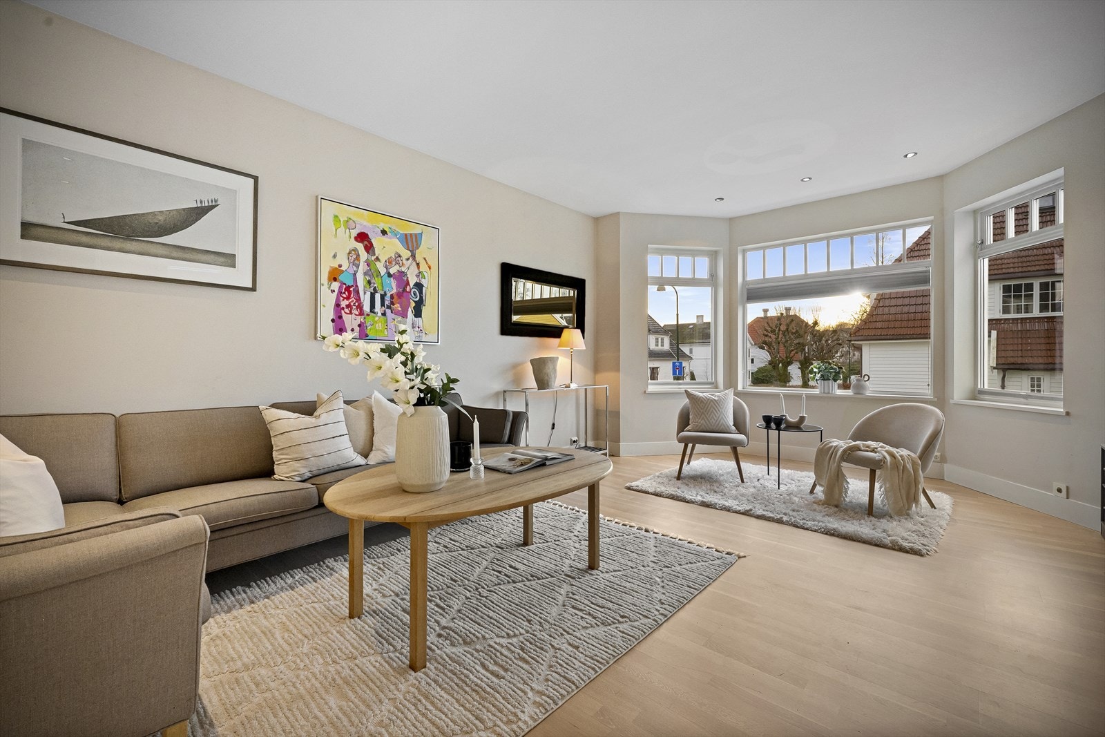 Lys og romslig stue med store vinduer som slipper inn naturlig lys. Galleribilde