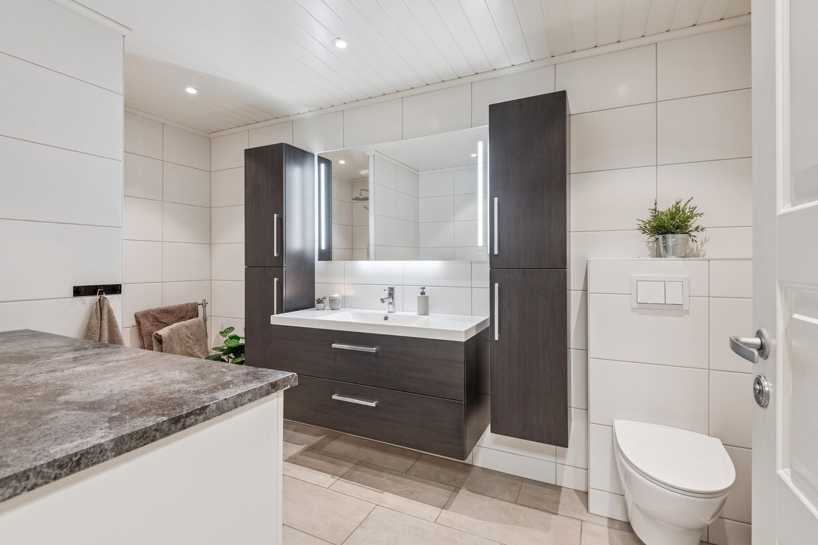 Flislagt bad med varmekabler i gulv og vegghengt toalett. Galleribilde