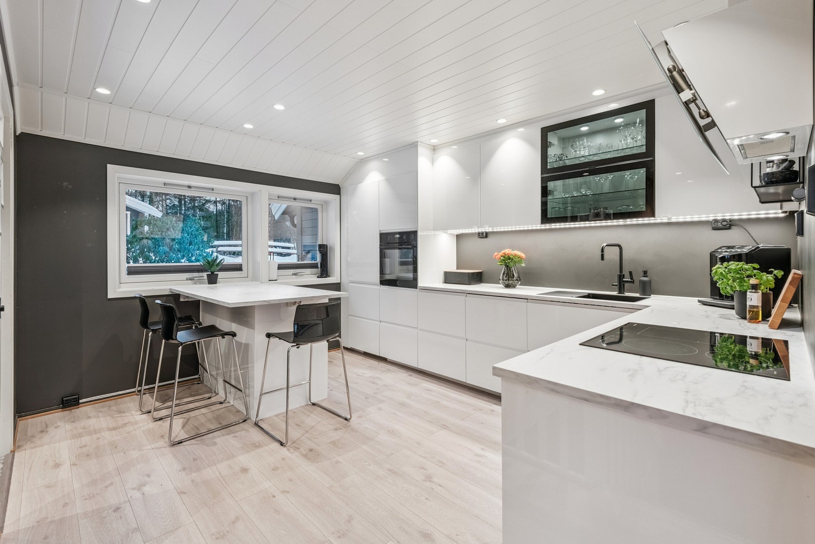 Romslig og lyst kjøkken med mye skap- og benkeplass. Vinduer over kjøkkenøya hvor du ser mot den lille skogen på friarealet utenfor. Galleribilde