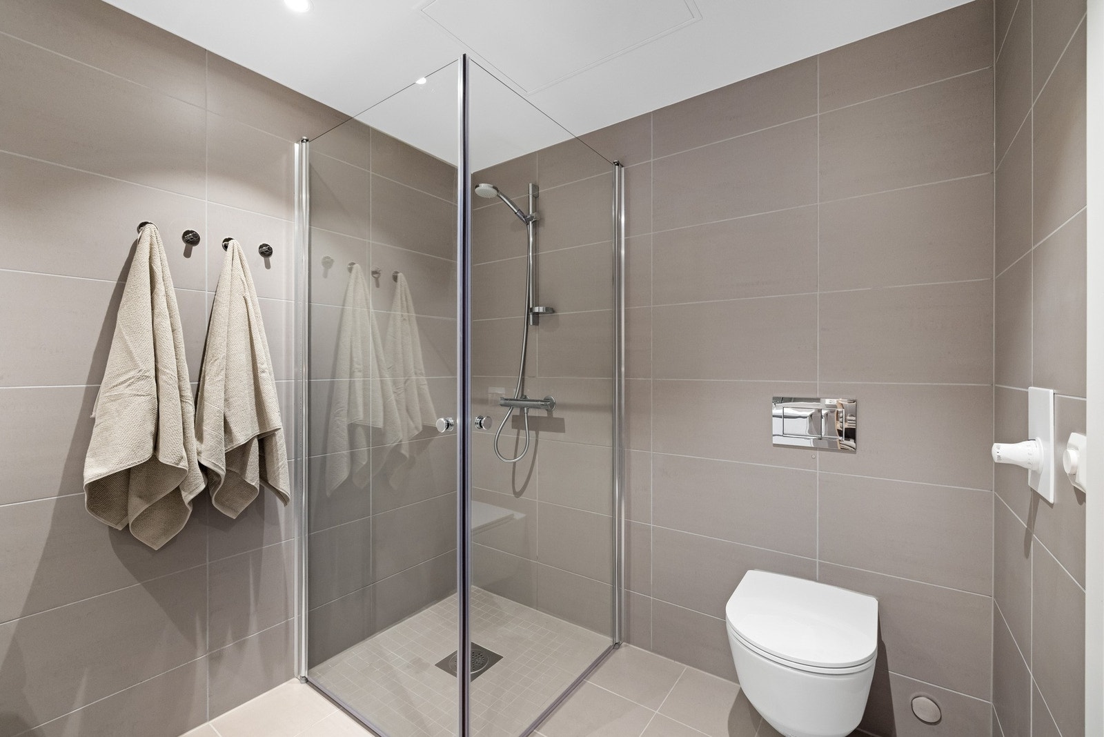 Her får du dushjørne med innfellbare glassdører og dusjarmatur, vegghengt toalett og opplegg for vaskemaskin og tørketrommel. Galleribilde