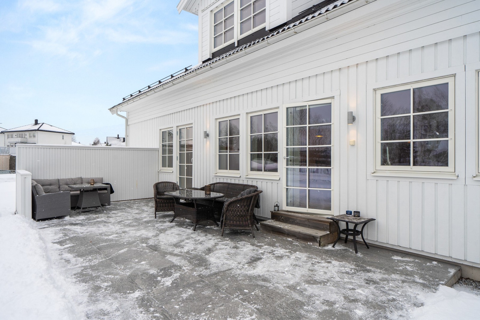 Terrassen har støpt betongplate på mark med løse terrassefliser og levegg av tre. Det er også montert utebelysning og utvendig stikkontakt. Galleribilde
