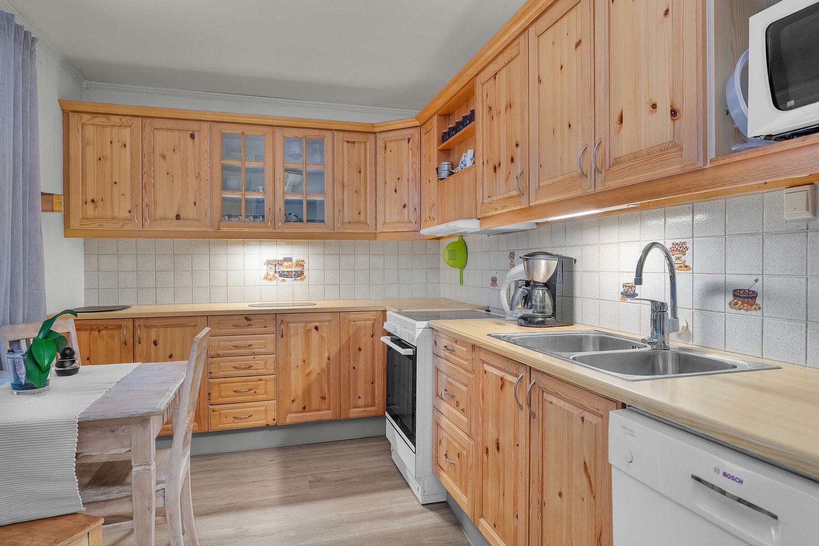 Kjøkkenet har profilerte fronter, godt med skap- og benkeplass, og opplegg for frittstående hvitevarer. Galleribilde