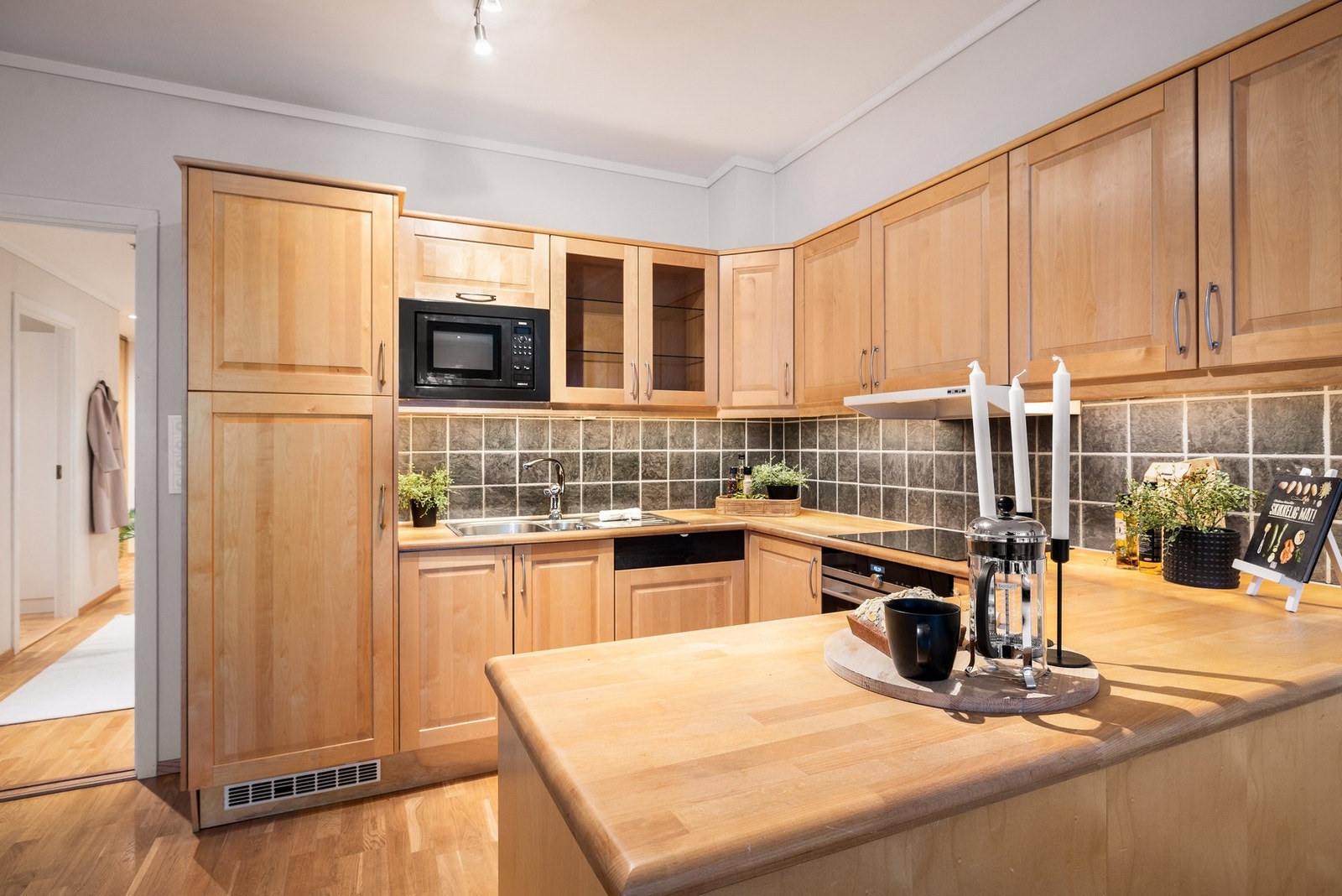 Integrerte hvitevarer er induksjonsplatetopp, stekeovn, mikrobølgeovn, oppvaskmaskin og kjøleskap Galleribilde