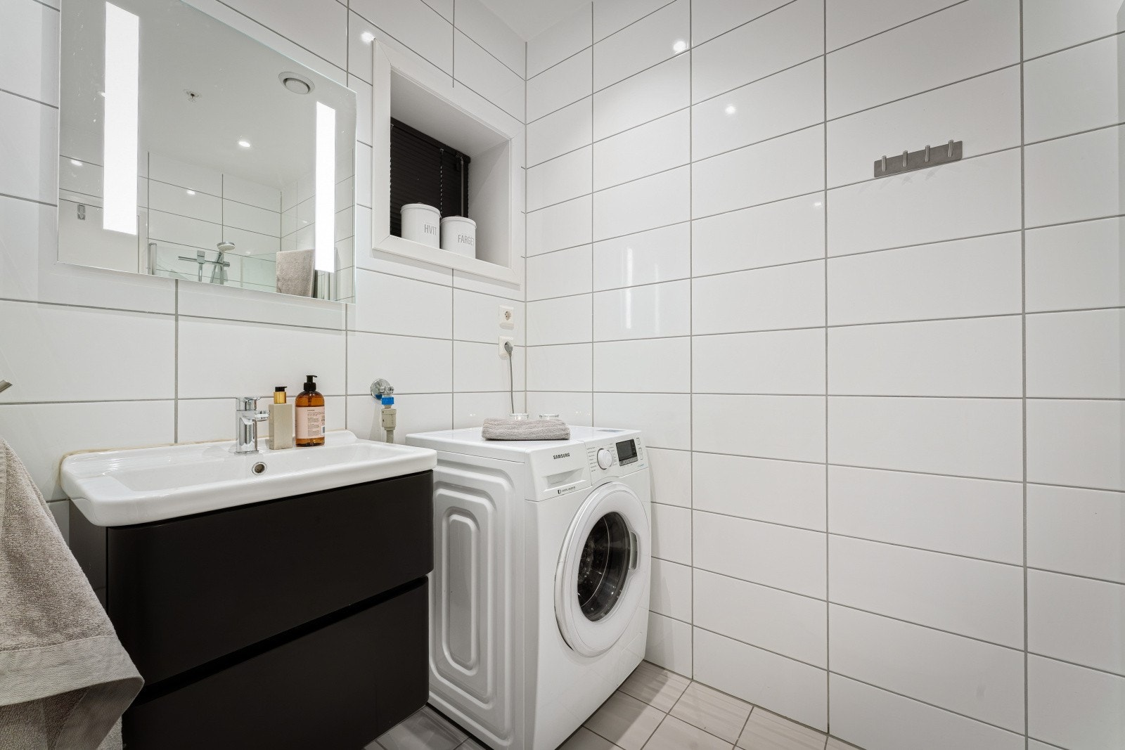 Leilighetens bad fremstår i god stand med tidløs innredning og god plass til vaskemaskin og andre nødvendigheter. Galleribilde