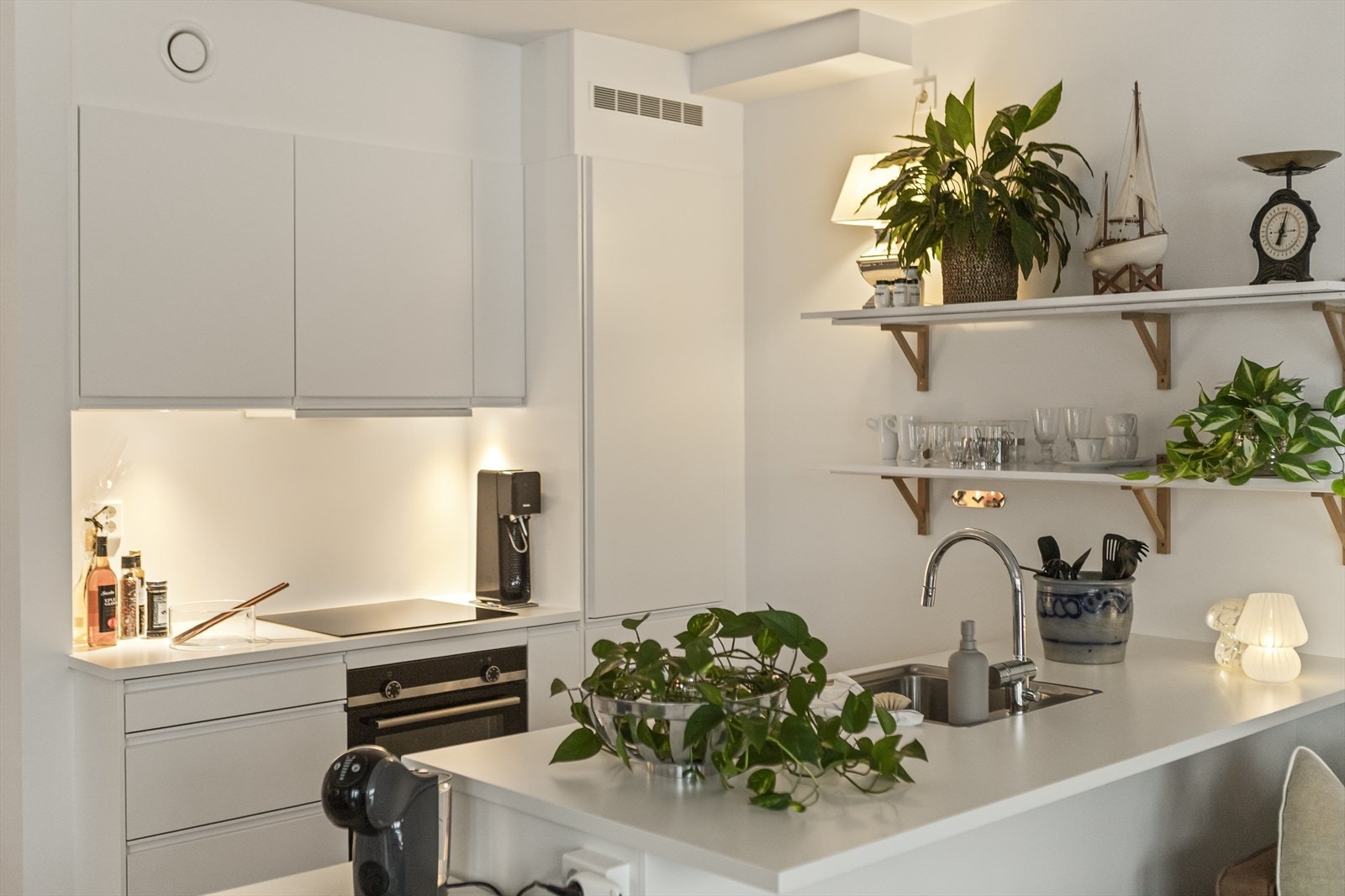 Alt av hvitevarer er integrert; kombinert kjøle- og fryseskap, platetopp, stekeovn, samt oppvaskmaskin. Kjøkkenventilator i overskap. Galleribilde