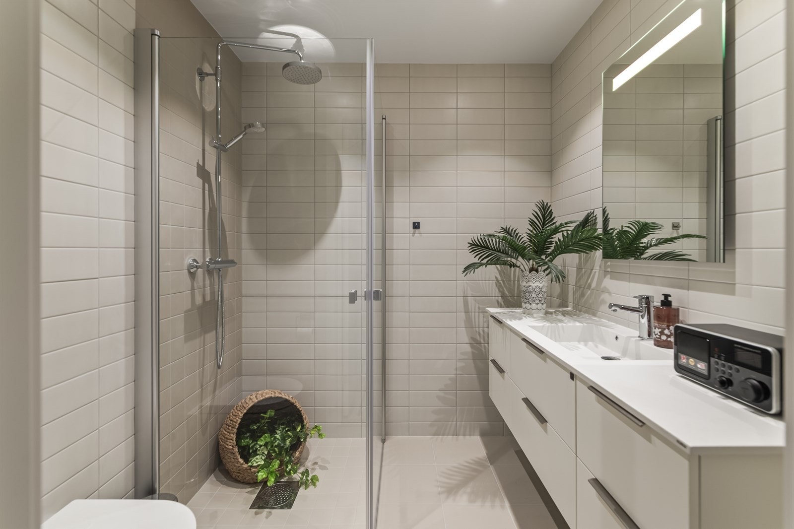 Rommet er pent og moderne med fliser på både vegger og gulv. Galleribilde