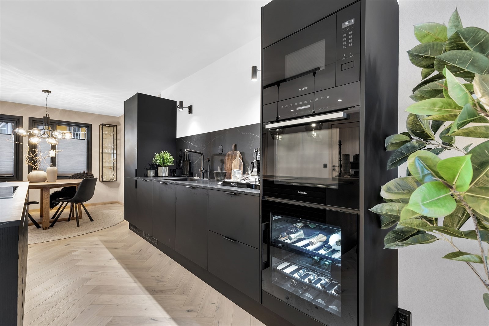 Svanekjøkken med påkostede hvitevarer i Miele og Bosch, Groe kran med kokevann og vinkjøler. Galleribilde