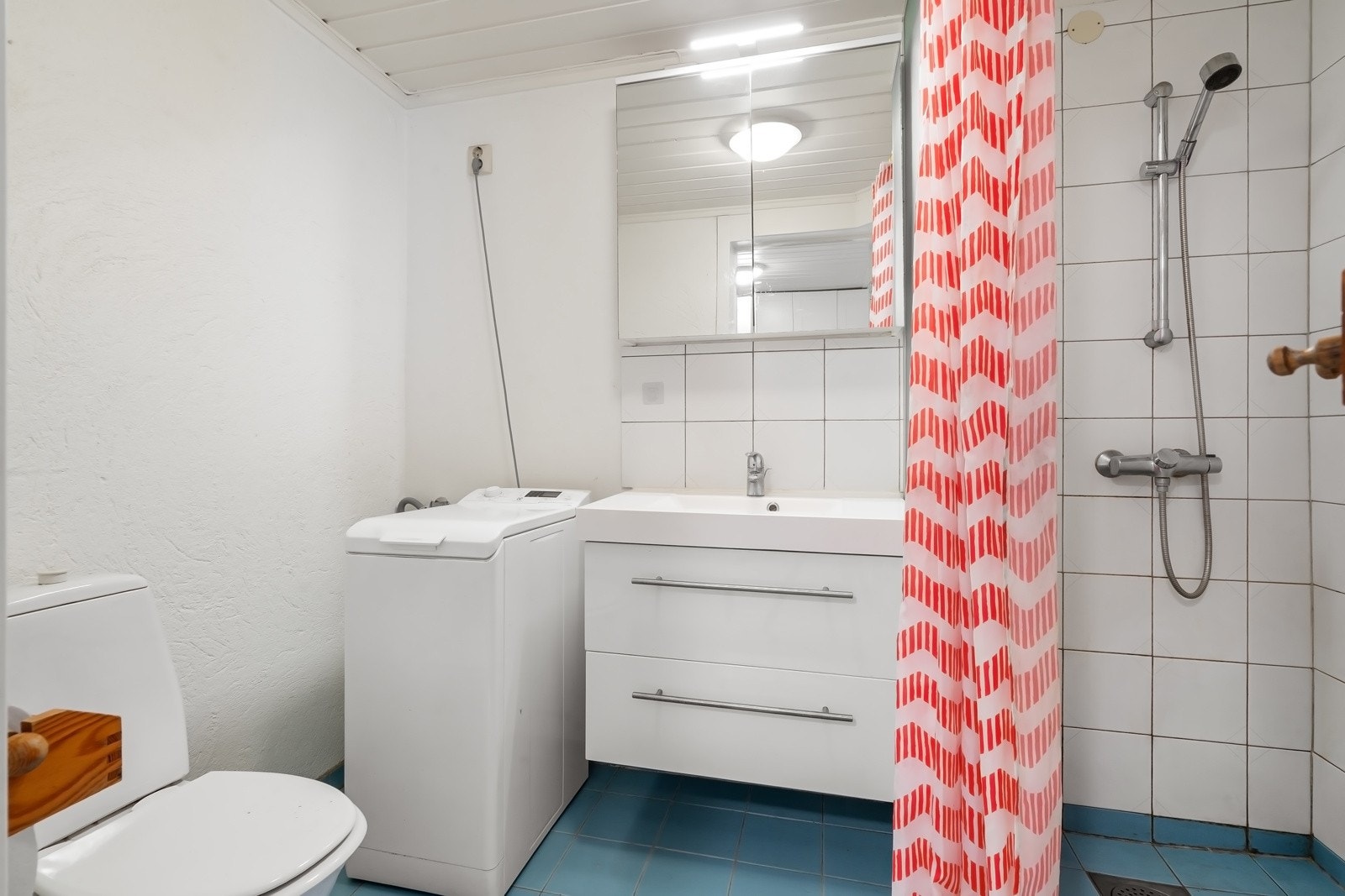 Badet er utstyrt med toalett, dusjhjørne og opplegg for vaskemaskin. Galleribilde