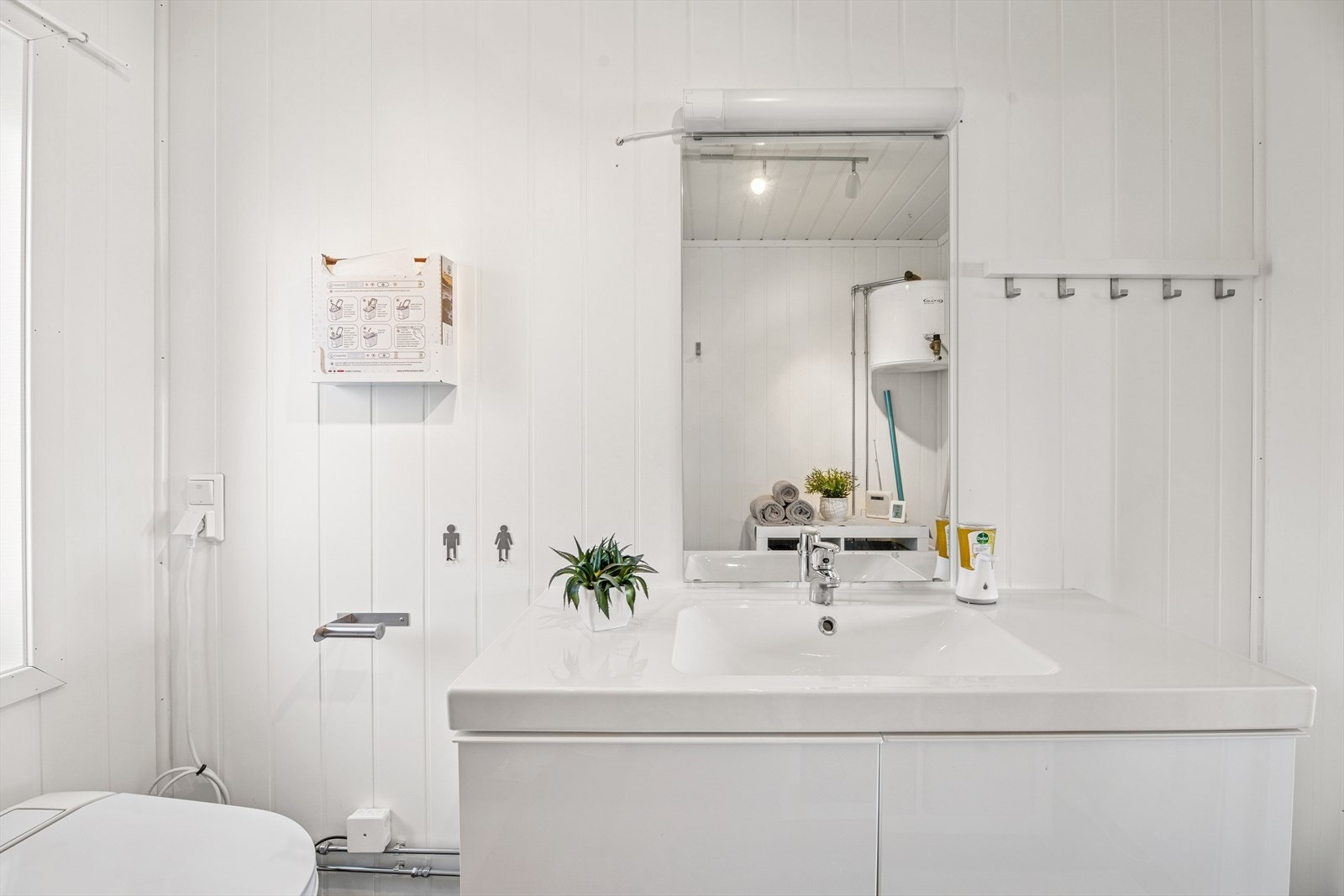 Det er flislagt gulv med elektriske varmekabler og baderomsplater og malte plater på veggene. Galleribilde