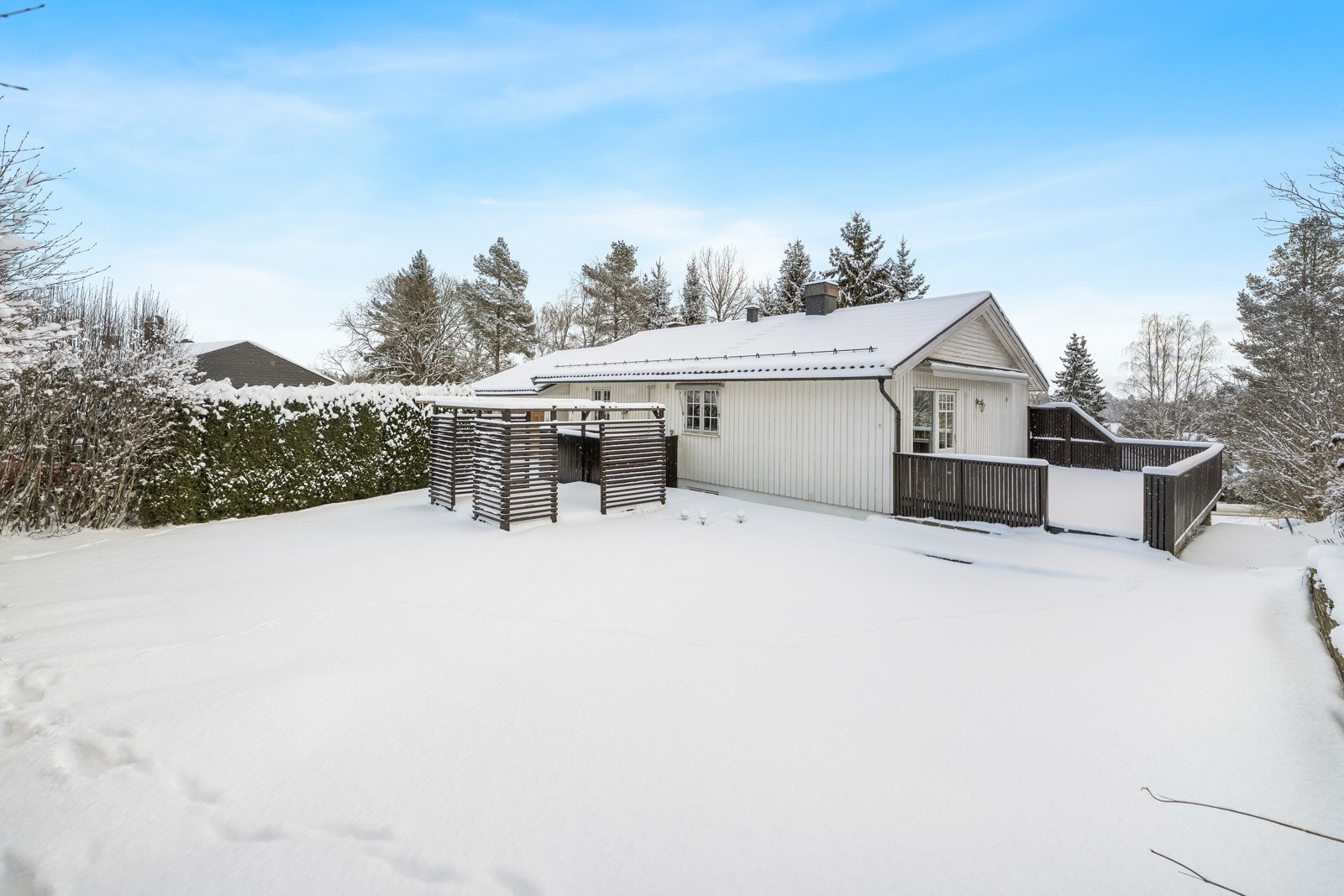 Eiendommen har en stor og solrik tomt på 1 057 kvm med en innbydende hage fordelt over to nivåer, med gressplen og variert beplantning på begge sider av boligen - perfekt for familien! Galleribilde
