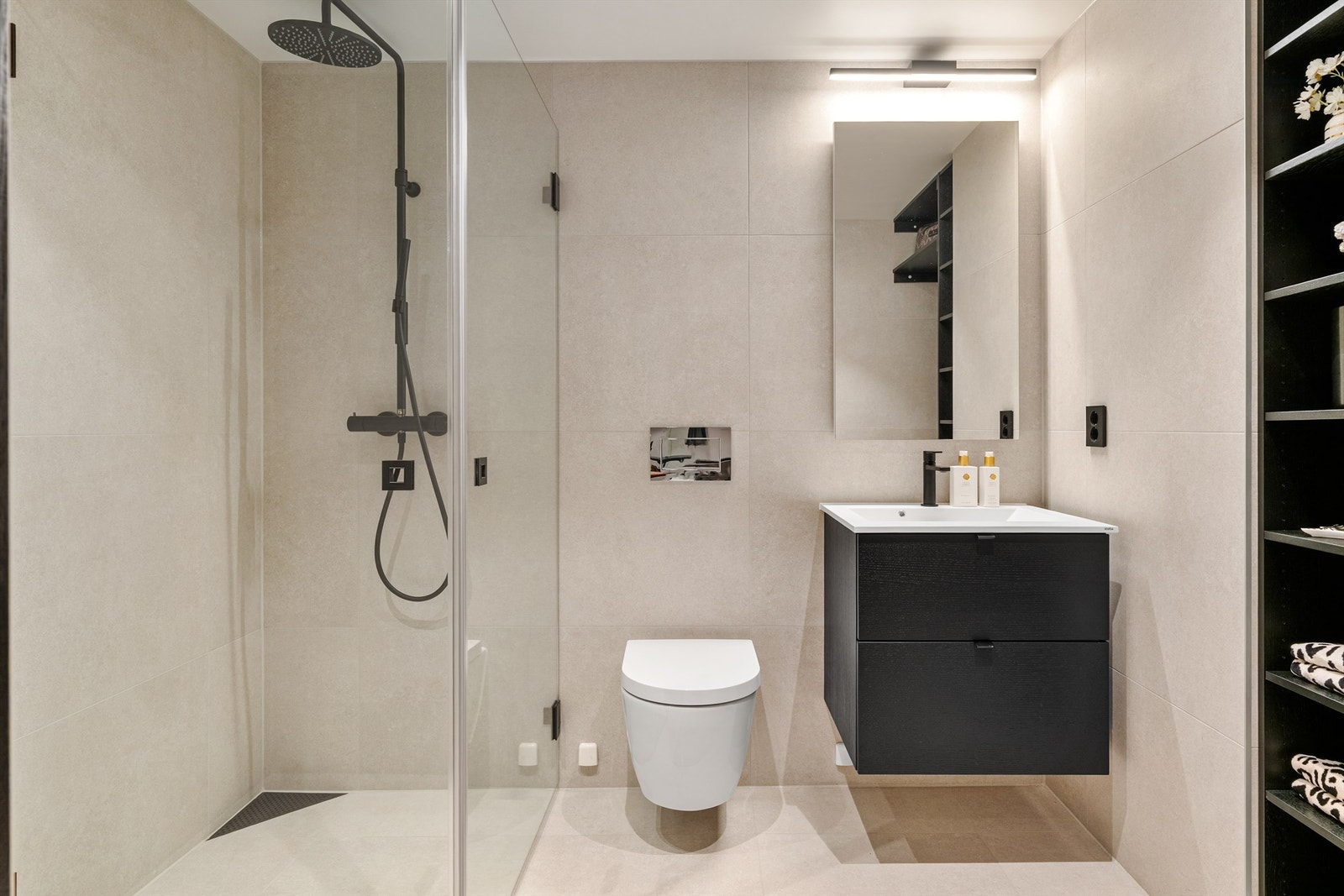 Vegghengt WC, dusjhjørne med regnfallsdusj og servant med skuffeseksjon medfølger. Galleribilde