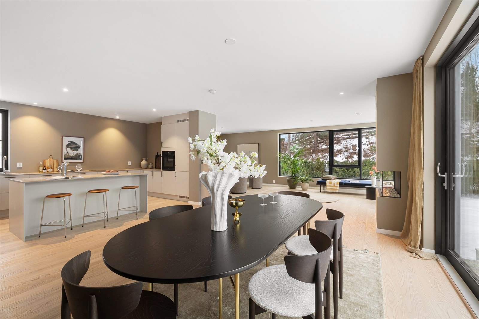 Store vindusflater som strekker seg fra gulv til tak gir naturlig lys i oppholdsrommene, samt skaper en god atmosfære Galleribilde