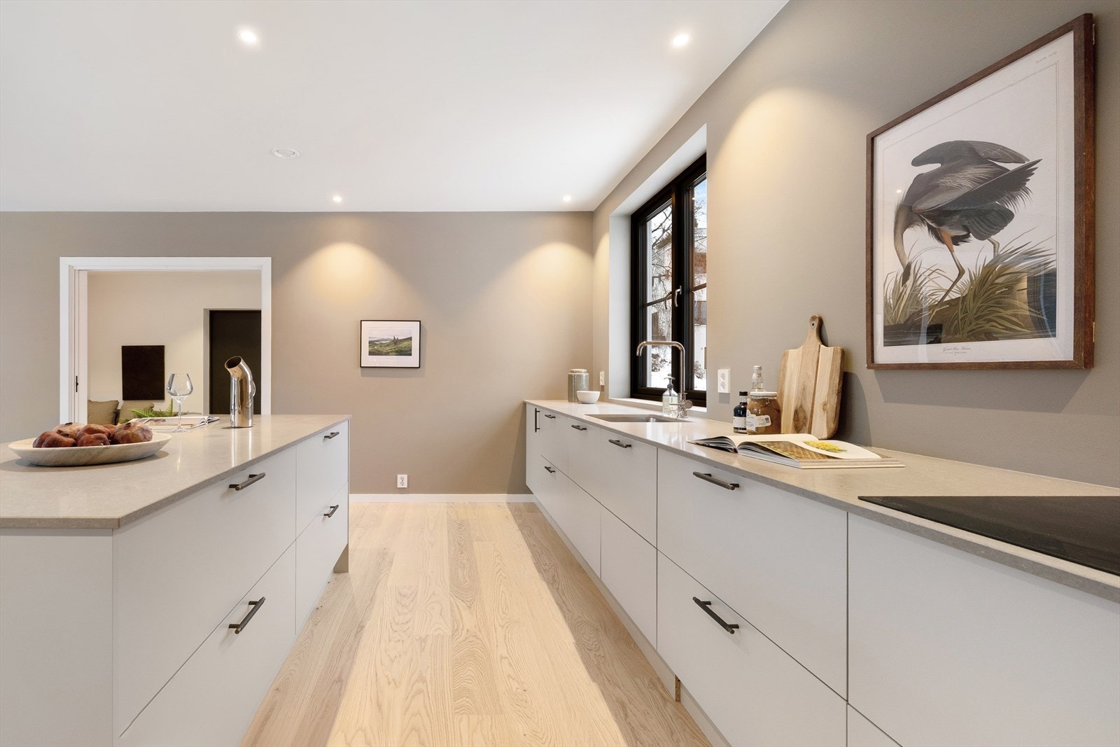 Kjøkkenet er utstyrt med integrerte hvitevarer, herunder komfyr, platetopp med integrert avtrekksvifte, oppvaskmaskin og kjøl/frys Galleribilde