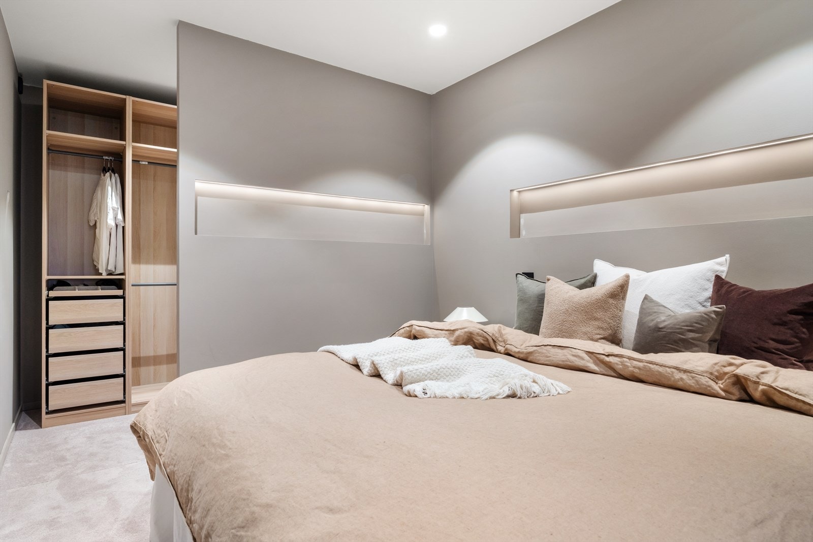 Hovedsoverommet byr på gjennomtenkt belysning, en delvis adskilt garderobeløsning og et lunt vegg-til-vegg-teppe. Galleribilde