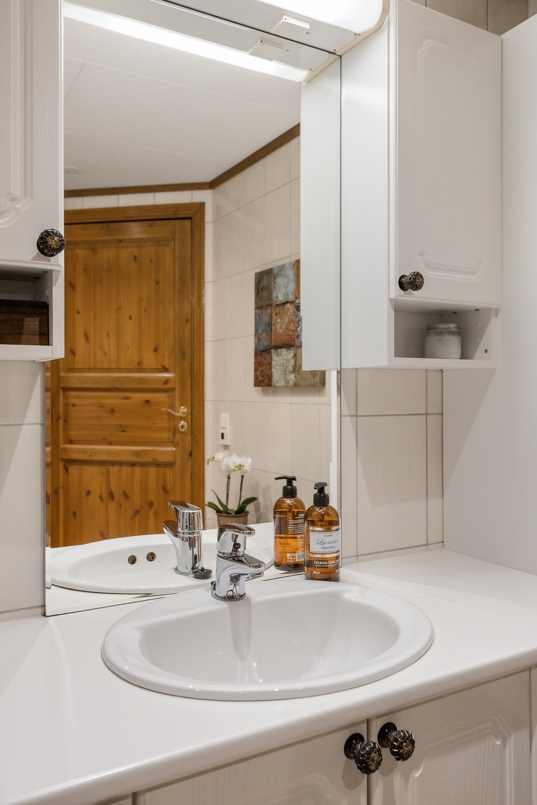 Nedfelt servant og veggmontert speil gir en praktisk vaskesone. Galleribilde