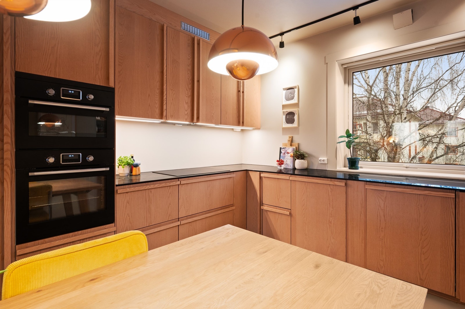 Hvitevarene er sømløst integrert i innredningen og består av platetopp, stekeovn, kombinert varmluftsovn/micro, to oppvaskmaskiner og kjøl/fryseskap. Galleribilde