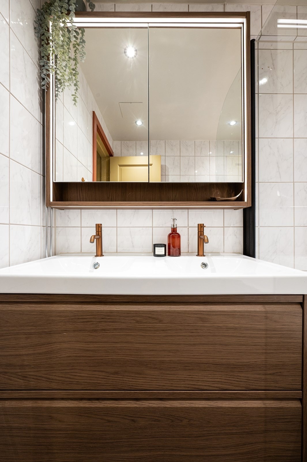 Praktisk dobbelservant og et stort speilskap med integrert belysning og oppbevaring. Galleribilde